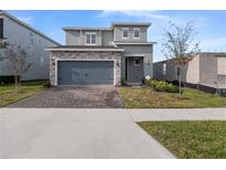 Charming two-story home featuring a stone-accented facade and a two-car garage at 4409 Lions Gate Ave, Clermont, FL 34711