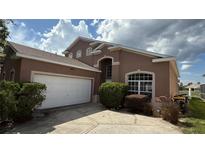 Charming home with a well-maintained lawn, large driveway, and a two-car garage at 513 Bailey Cir, Davenport, FL 33897