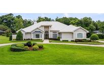 Stunning single-story home with a manicured front yard, a white tile roof, and elegant landscaping at 740 Bear Creek Cir, Winter Springs, FL 32708