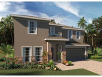 Two-story home showcasing a neutral stucco exterior, stone accents, and a paver driveway and walkway at 7986 Syracuse Dr, Clermont, FL 34714