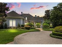Stately home boasts professional landscaping, brick circular drive and decorative fountain at 8542 Eden Park Rd, Orlando, FL 32810