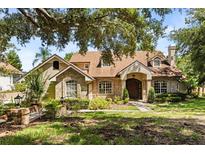 Charming brick home with a well-manicured lawn and mature trees providing ample shade at 8800 Torey Pines Ter, Orlando, FL 32819