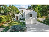 Stunning modern home with a lush green lawn, complemented by a two-car garage and white stucco exterior at 1150 Via Salerno, Winter Park, FL 32789