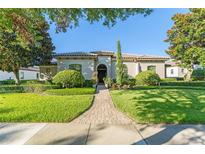 Beautiful one-story home with a landscaped front yard, brick walkway, and a well-manicured lawn at 11754 Waterstone Loop Dr, Windermere, FL 34786