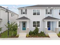 Charming townhouse with a teal door, stone accents, and a well-maintained front yard at 1294 Tarflower Dr, Winter Springs, FL 32708