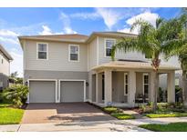Inviting two-story home with a two car garage, covered porch, and beautifully landscaped front yard at 16564 Silversaw Palm Dr, Winter Garden, FL 34787