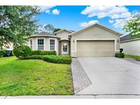 Charming single-story home featuring a well-manicured lawn and a two-car garage at 2216 Sequoia Way, Davenport, FL 33896