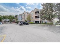Exterior view of a condominium complex with ample parking at 3428 Soho # 301, Orlando, FL 32811