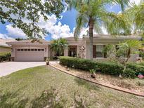 Charming single-story home featuring a well-manicured lawn, mature trees, and a two-car garage at 3556 Sunset Isles Blvd., Kissimmee, FL 34746