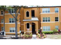 Inviting condo complex featuring large windows, manicured landscaping, and covered entryway at 4606 Commander Dr # 1126, Orlando, FL 32822