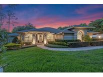 Charming home showcasing lush green lawn, beautiful landscaping, and inviting architecture at dusk at 5102 Round Tree Ct, Orlando, FL 32819
