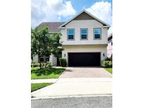 Charming two-story home featuring a manicured lawn, neutral paint, brick driveway, and a two-car garage at 813 Marsh Reed Dr, Winter Garden, FL 34787