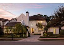 Stunning home featuring lush landscaping, a clay tile roof, and a circular brick driveway at 10143 Mattraw Pl, Golden Oak, FL 32836