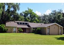 Beautiful one-story home with a well-maintained lawn and mature trees providing shade at 1102 Winter Springs Blvd, Winter Springs, FL 32708