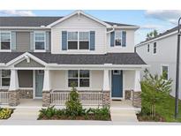 Charming townhome featuring a covered porch with stone accents and blue shutters at 1299 Tarflower Dr, Winter Springs, FL 32708