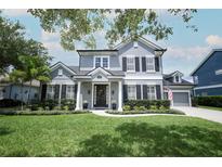Charming two-story home featuring a well-manicured lawn, shutters, and a welcoming front porch at 14252 Anastasia Ln, Orlando, FL 32828