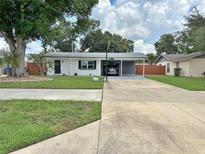 Charming single-story home featuring a carport, well-maintained lawn, and mature trees at 1428 Glendale St, Lakeland, FL 33803