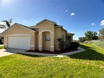 Charming single Gathering home with a well-manicured lawn and neutral exterior at 1433 Bluff Loop, Dundee, FL 33838