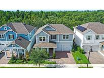 Charming two-story home featuring a brick driveway, two-car garage, manicured lawn, and lovely landscaping at 15343 Lebeau Loop, Winter Garden, FL 34787