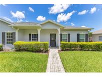 Charming home with a well-manicured lawn, walkway, and inviting covered porch with stately columns at 157 Bell Tower E Xing, Kissimmee, FL 34759