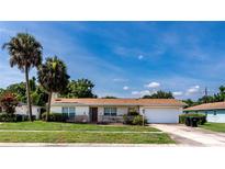 Charming single-story home featuring a well-manicured lawn and beautiful palm trees at 1746 Valley Forge Road, Orlando, FL 32806
