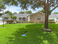 Charming single-story home featuring a brick exterior, manicured lawn, and mature trees at 1850 Geronimo Trl, Maitland, FL 32751
