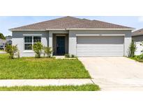Charming single-story home with a well-maintained lawn and attached two-car garage at 200 Garnet Ave, Kissimmee, FL 34758