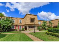 Inviting townhome showcases manicured lawn, lush landscaping, and charming architectural details at 200 Saint Andrews Blvd # 2607, Winter Park, FL 32792