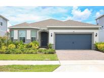 Charming single-Gathering home featuring a well-maintained lawn and a two-car garage at 2612 Summer Clouds Way, Kissimmee, FL 34744