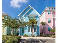 Charming two-story home with colorful exterior, front yard, and sunny sky at 3004 Latitude Ln, Kissimmee, FL 34747
