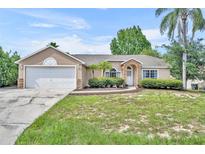Charming single-story home features a stone-accented facade and a well-maintained lawn at 335 Oakpark Loop, Davenport, FL 33837