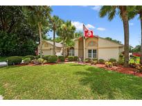Well-manicured lawn with palm trees and landscaping in front of the charming single-story home at 5704 Bay Side Dr, Orlando, FL 32819