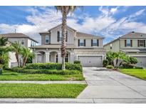 Two-story home showcasing manicured landscaping, a two-car garage and a welcoming front entrance at 7895 Pleasant Pine Cir, Winter Park, FL 32792