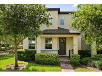 Charming two-story home featuring manicured landscaping, a welcoming porch, and a dark-colored front door at 9814 Amber Chestnut Way, Winter Garden, FL 34787