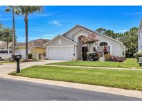 Charming single-Gathering home with a well-manicured lawn, mature landscaping, and a two-car garage at 1019 Lake Berkley Dr, Kissimmee, FL 34746