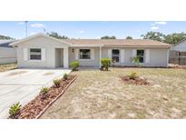 Charming single-story home featuring a tidy front yard with fresh landscaping and a brick exterior at 105 E Magnolia St, Davenport, FL 33837