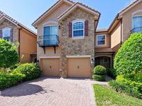 Charming two-story home featuring a stone facade, tile roof, and a two-car garage at 10653 Belfry Cir, Orlando, FL 32832