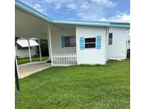 Charming single-story home featuring a carport, a small picket fence and blue trim details at 1401 W Highway 50 # 152, Clermont, FL 34711