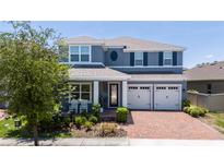 Charming two-story home with a well-manicured lawn and brick driveway at 15716 Sweet Lemon Way, Winter Garden, FL 34787