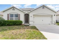 Charming single-story home featuring a well-manicured lawn and an attached two-car garage at 1864 Green Dragon Dr, St Cloud, FL 34771