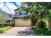 Charming two-story home with a two car garage and brick paved driveway and lush landscaping at 251 Domus Ln, Casselberry, FL 32707