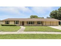 Inviting single-story home featuring a well-manicured lawn and charming walkway to the front door at 2908 Clear Way, Orlando, FL 32805