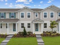 Charming townhome with well-manicured lawn, complemented by a welcoming walkway and vibrant green door at 3235 Gardenia Reserve St, Apopka, FL 32712