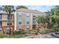 A condominium complex with a stucco exterior and well-maintained landscaping at 3946 Versailles Dr # 3946B, Orlando, FL 32808
