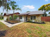 Charming home featuring stone accents, a covered porch, and a beautifully landscaped front yard at 412 Ranch Trl, Casselberry, FL 32707
