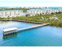 Scenic view of condos with a beautiful pier on the water, surrounded by lush greenery at 4628 Harbour Village Blvd # 2308, Ponce Inlet, FL 32127