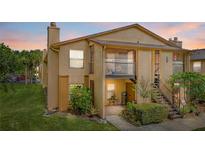 Charming two-story condo featuring a well-manicured lawn, a second floor balcony, and a welcoming front entrance at 4870 S Semoran Blvd # 1904, Orlando, FL 32822