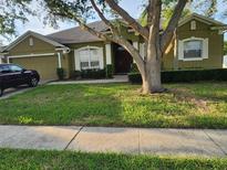 Charming home featuring a well-manicured lawn, a two-car garage, and traditional architecture at 4871 Fells Cove Ave, Kissimmee, FL 34744