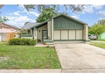 Charming single Gathering home featuring a well-maintained lawn and attached two car garage at 5308 Pinebury Ct, Orlando, FL 32808