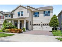 Charming two-story home features a manicured lawn, brick driveway, and a two-car garage at 9068 Sonoma Coast Dr, Winter Garden, FL 34787